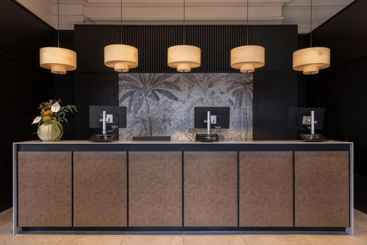 a lobby with a reception desk with lights at Apex Waterloo Place Hotel in Edinburgh