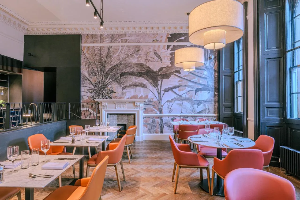 a restaurant with tables and chairs and a mural at Apex Waterloo Place Hotel in Edinburgh
