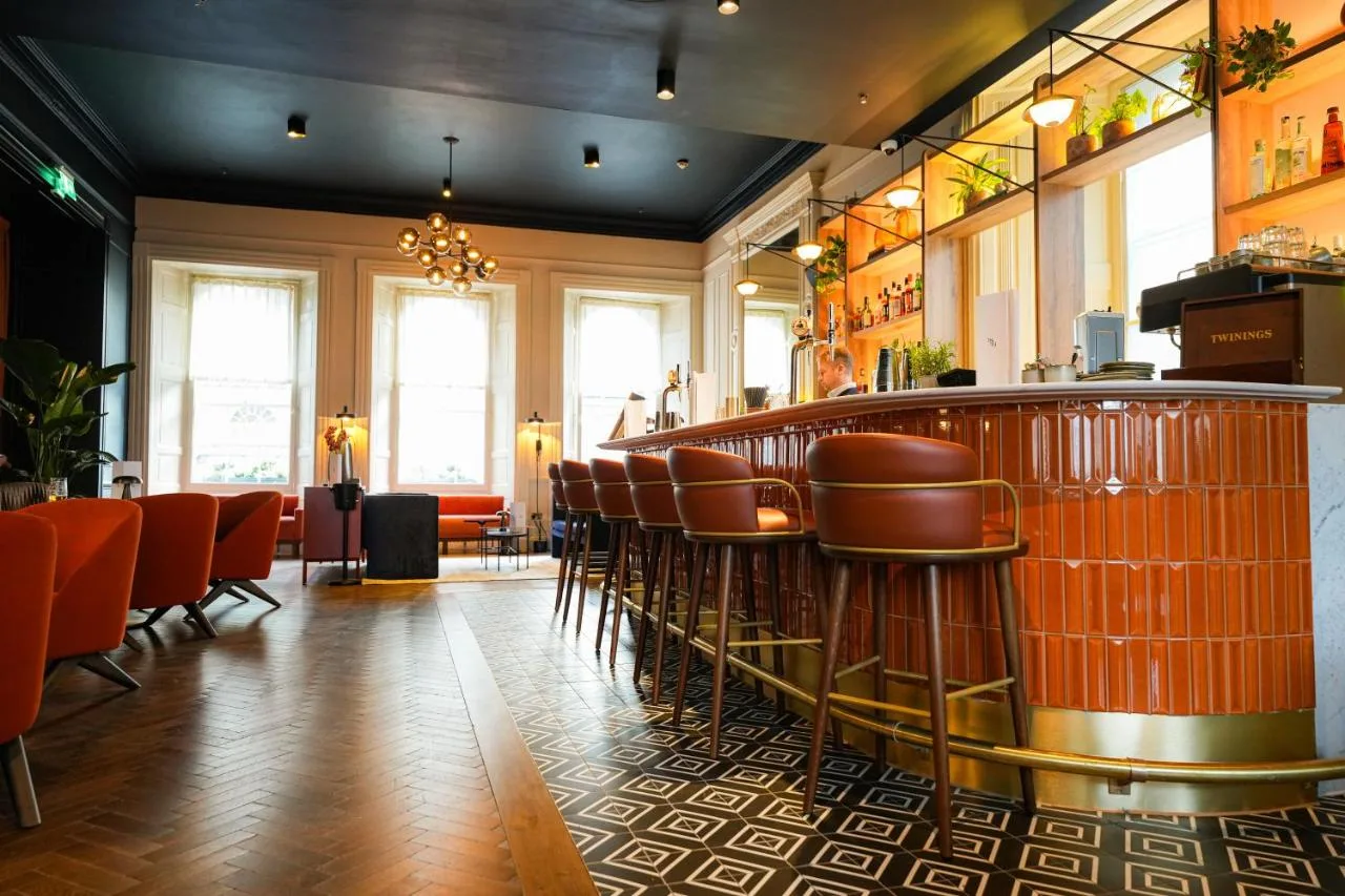 a bar in a restaurant with orange chairs at Apex Waterloo Place Hotel in Edinburgh